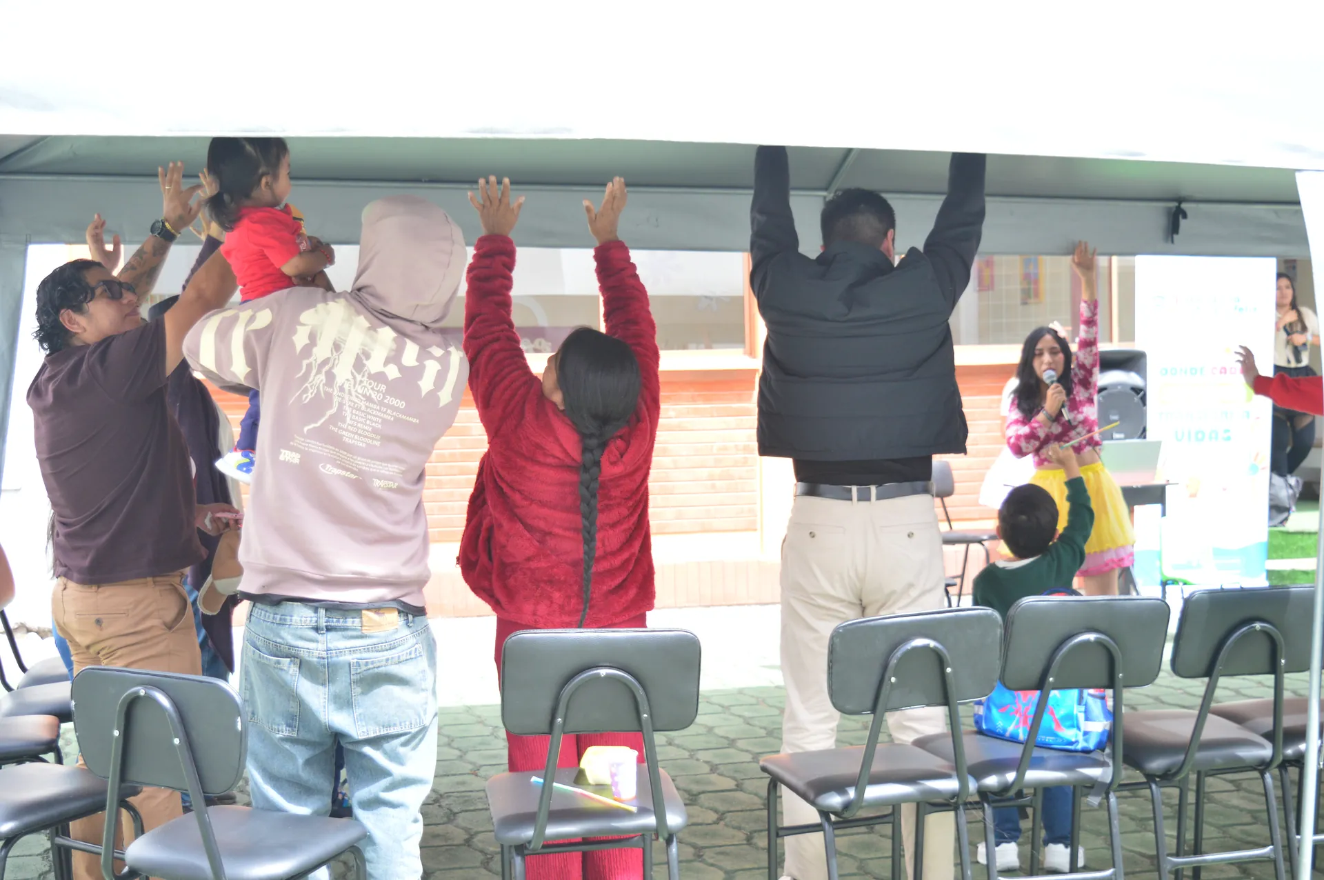 Familias participan en actividad grupal bajo la carpa